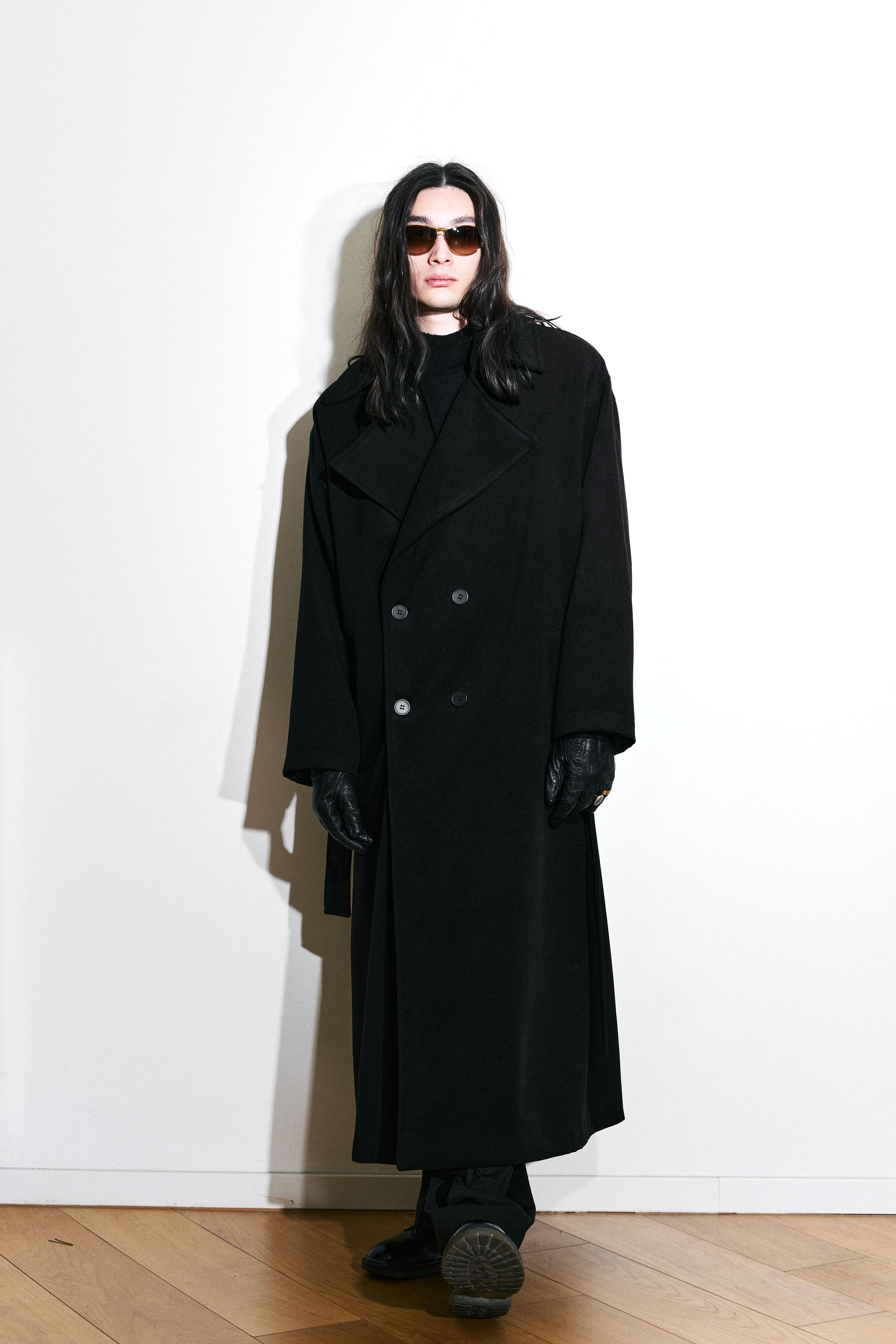 An oversized black greatcoat and leather gloves give AGIC's menswear a severe silhouette.
