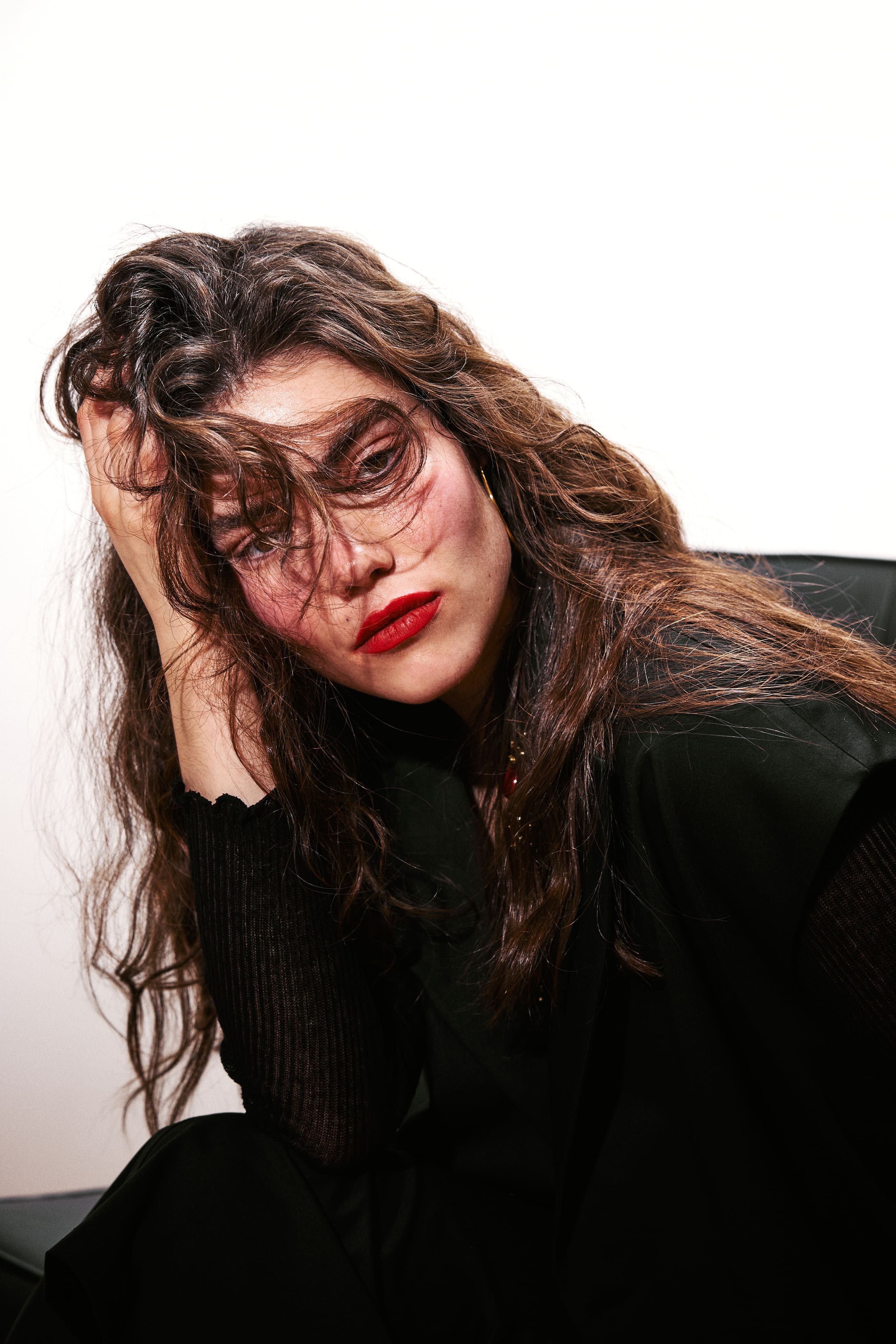 Head in hand, red lips through tangled curls close AGIC's lookbook on a smoky note.