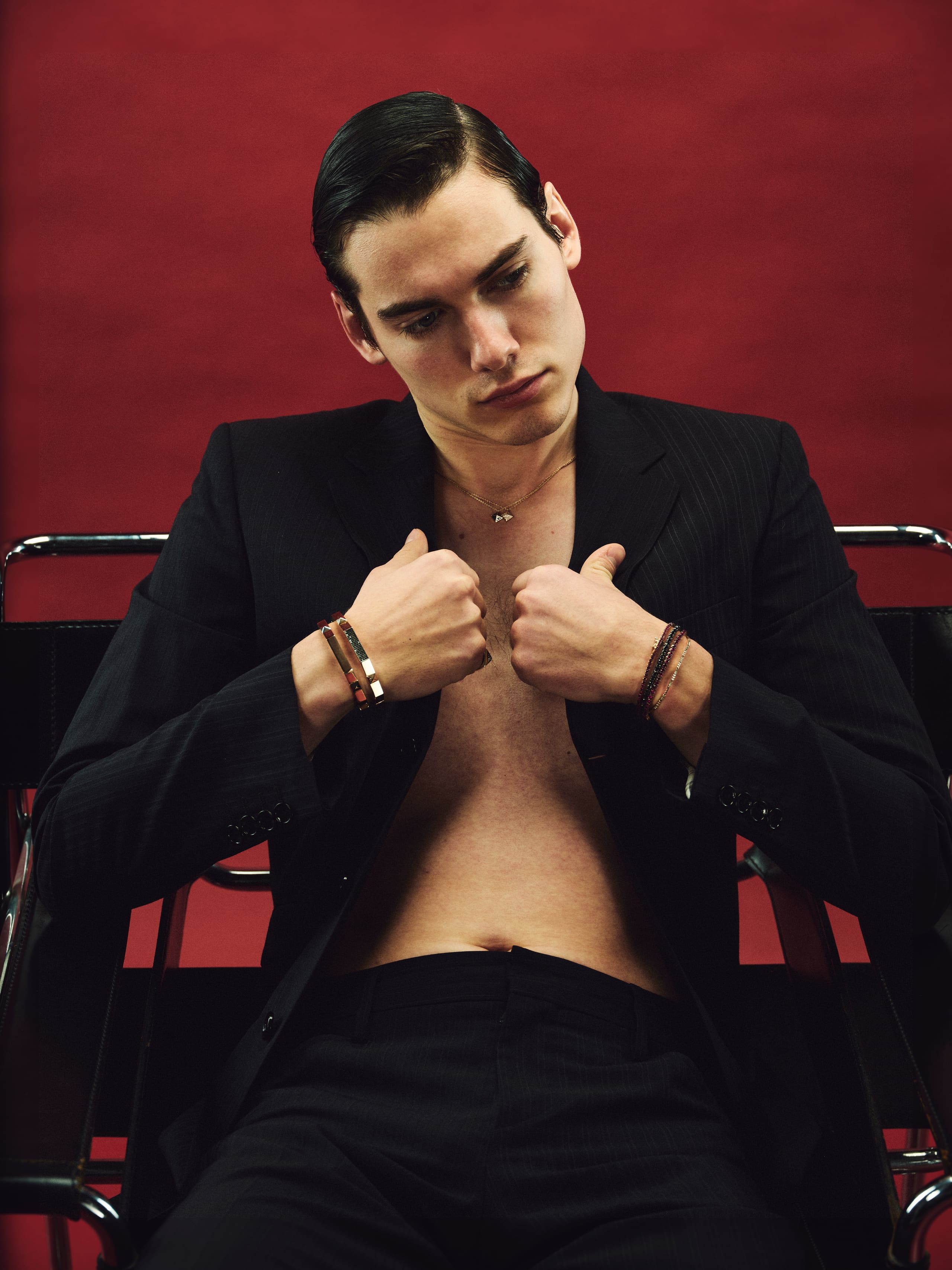Collar gripped in both fists, a downward glance under slicked hair in Dime Tribe's red room.