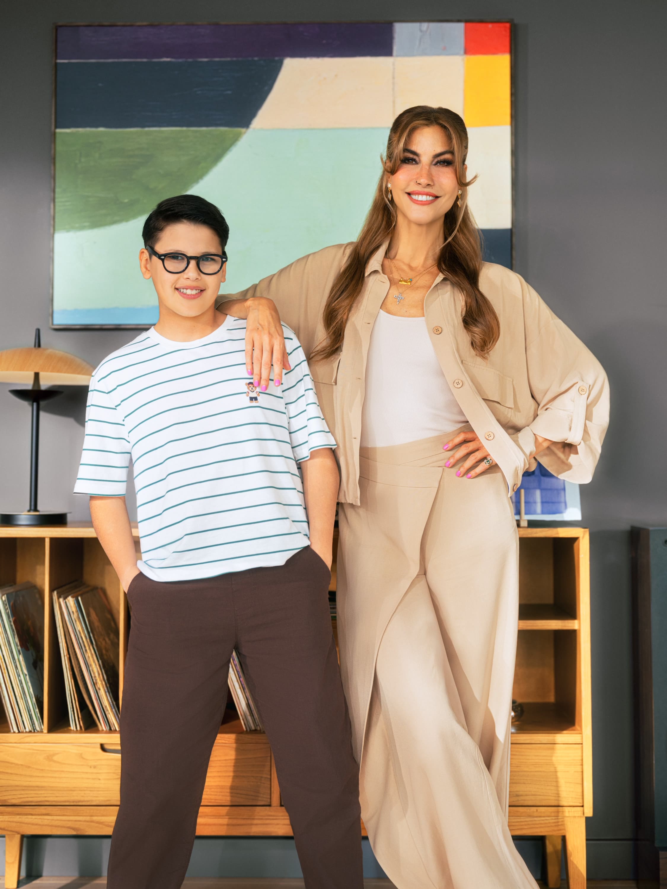 Çağla Şıkel rests a hand on her son Uzay Altuğ's shoulder, the pair in beige and striped cotton before an abstract canvas for LC Waikiki's Mother's Day campaign.