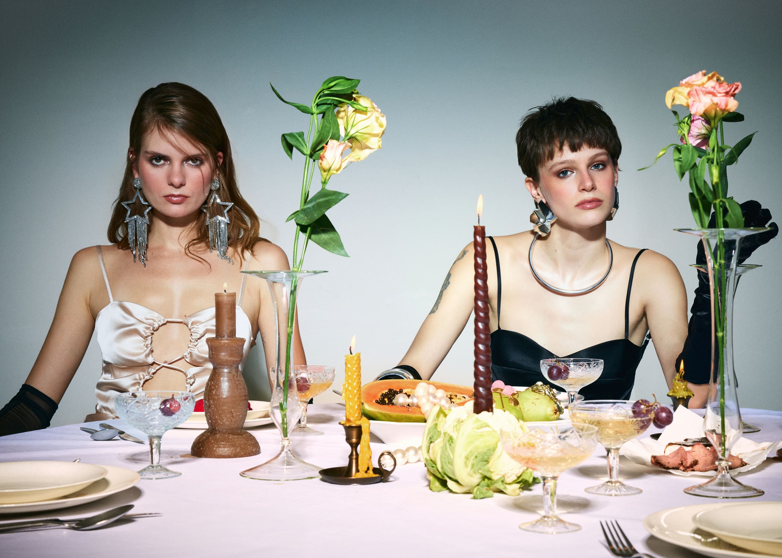Ivory and black Mers Silk slips hold a level gaze across a candlelit banquet of papaya, pearls and cut crystal.