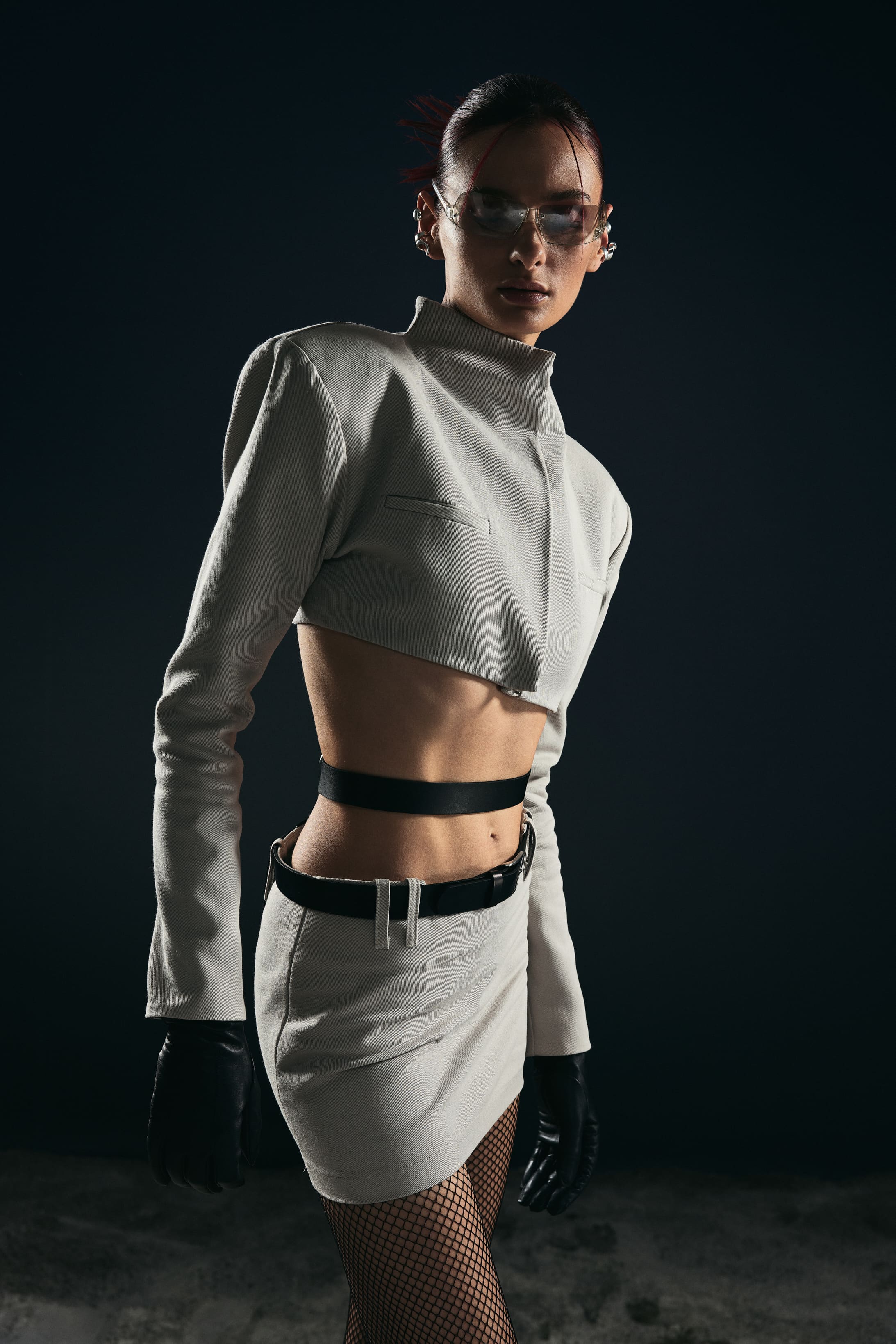 A stone-grey cropped jacket with squared shoulders meets fishnets and leather gloves in Mysamoon's uniform of the future.