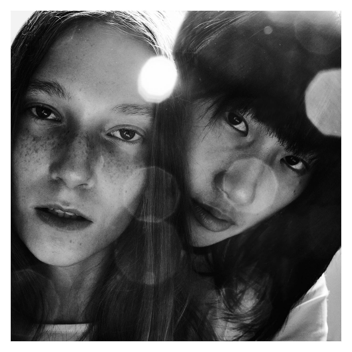 Two faces filling the frame through a bloom of lens flare, an intimate detail from ST Studio's Unborn story.